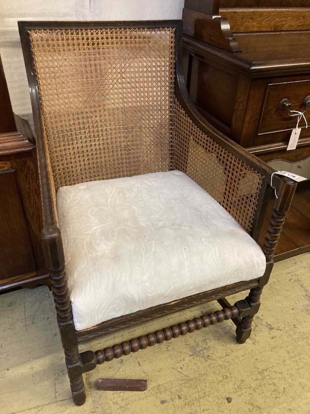 A 1920s oak bergere armchair